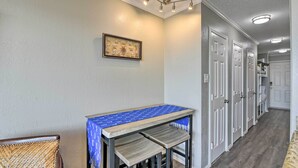 Un pasillo con un banco, un cuadro enmarcado en la pared y una puerta que da a una habitación.
