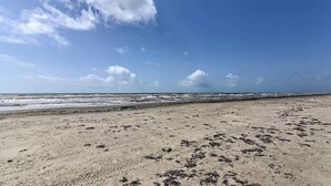 Une plage avec un ciel dégagé et des vagues.