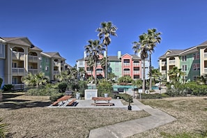 A residential complex with colorful buildings, palm trees, and a picnic area. - Walk to Beach: Lavish Resort Escape in Galveston! (Galveston)