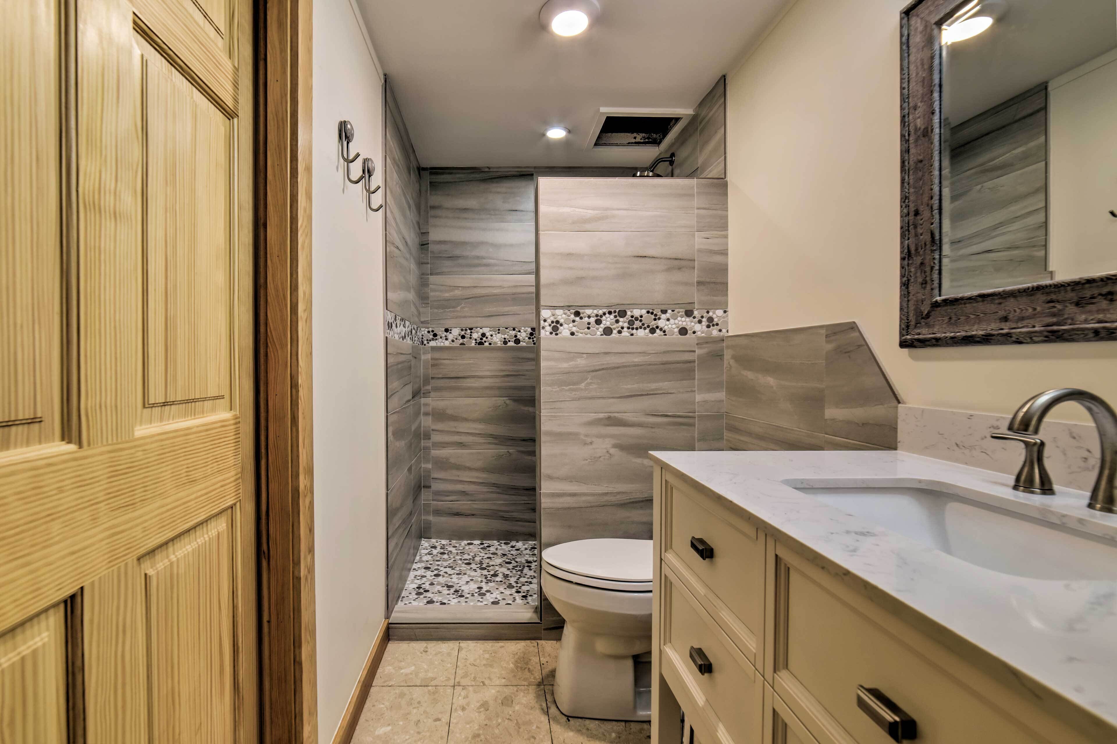 A bathroom with a shower, toilet, and vanity with a sink.