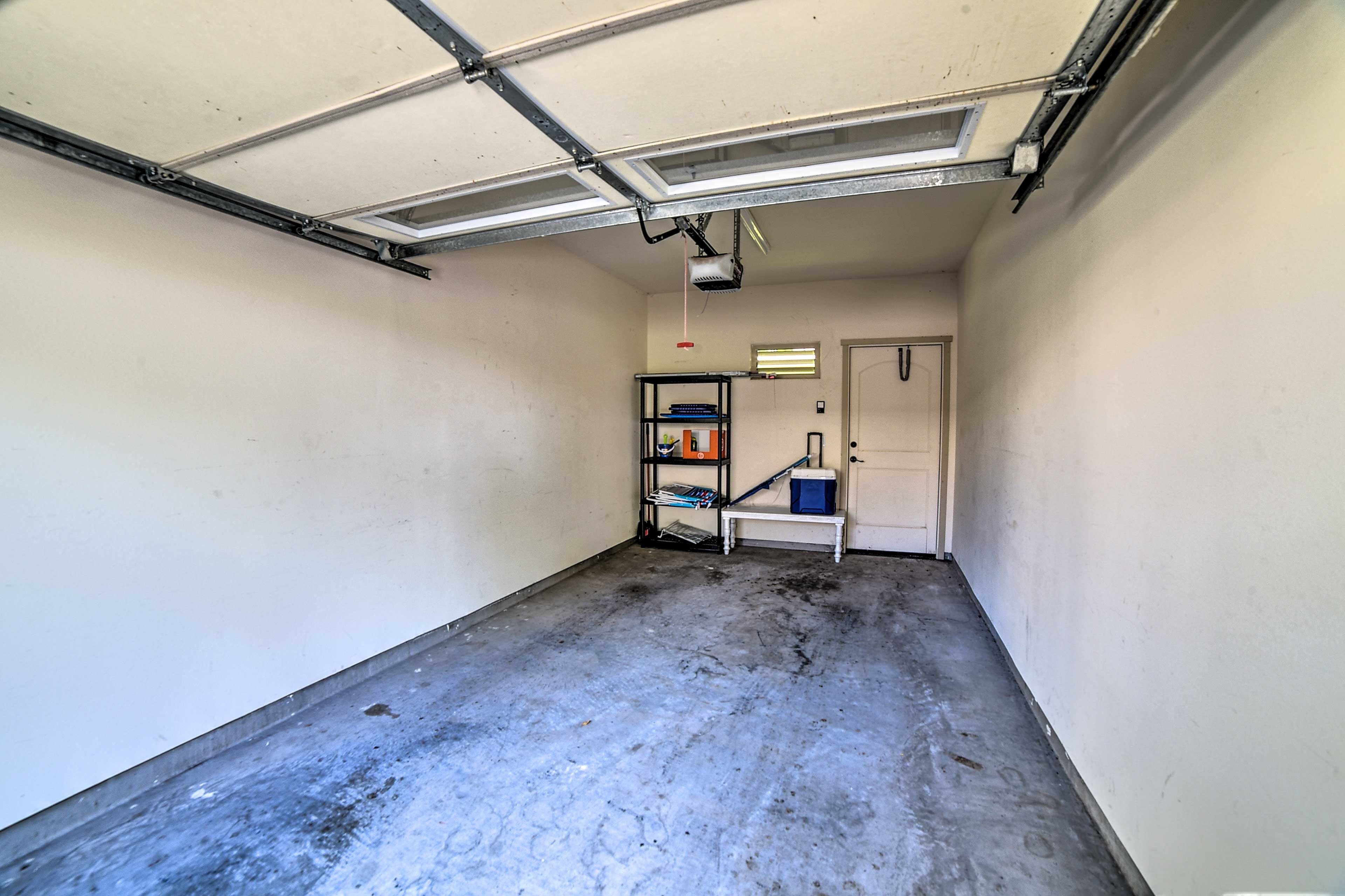 A narrow hallway with a concrete floor, a metal ceiling, and a door at the end.