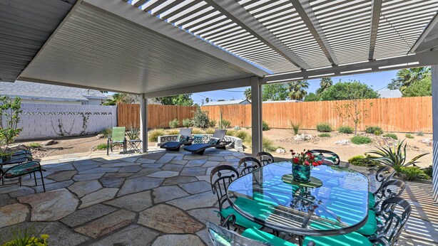 A covered patio with a stone floor, a glass table, and metal chairs. - Vintage Downtown Vegas Retreat < 3 Mi to Strip! (Las Vegas)