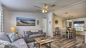 A living room with a sofa, coffee table, and a painting of a boat on the wall. - 2 Living Rooms: Crescent City Home (Crescent City)