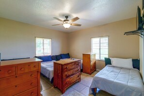A bedroom with two beds, a wooden dresser, and a ceiling fan. - Lakefront Retreat on Lake Ariana w/ EV Charger (Auburndale)