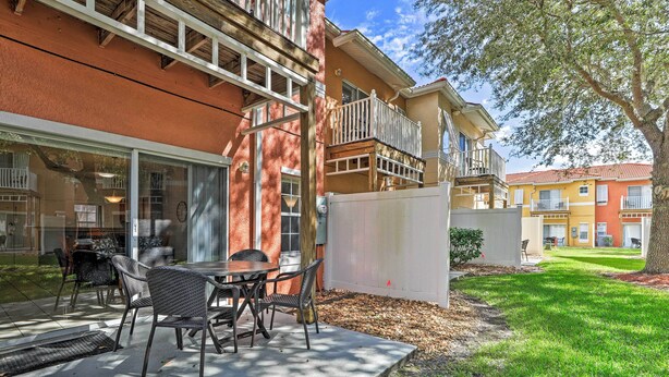 A patio with outdoor seating, a covered area, and a view of neighboring buildings. - Lake Berkley Retreat: Mins to Disney & Universal! (Kissimmee)