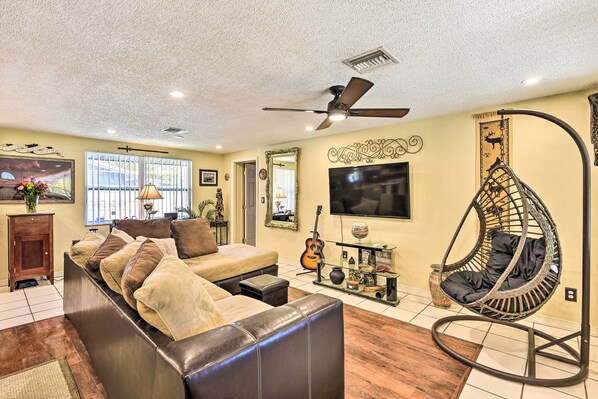 Relax in comfort with a large sofa, unique hanging chair, and flat-screen TV.