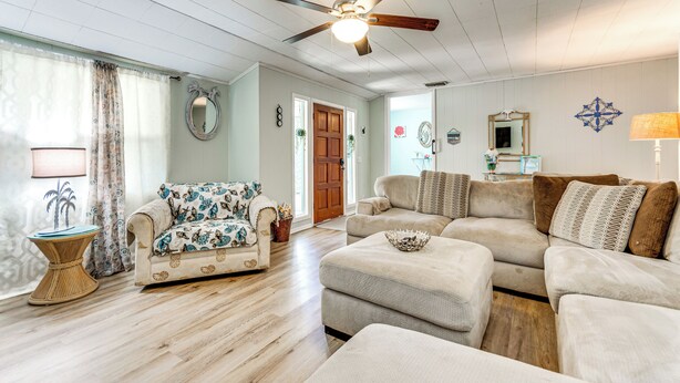 A living room with a ceiling fan, a sofa, a loveseat, and a coffee table. - Walk to Beach: Fort Walton Coastal Retreat (Fort Walton Beach)