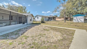 A modern residential area with houses, a covered outdoor seating area, and a fenced yard. - Marion Oaks Home < 20 Mi to Equestrian Center (Ocala)