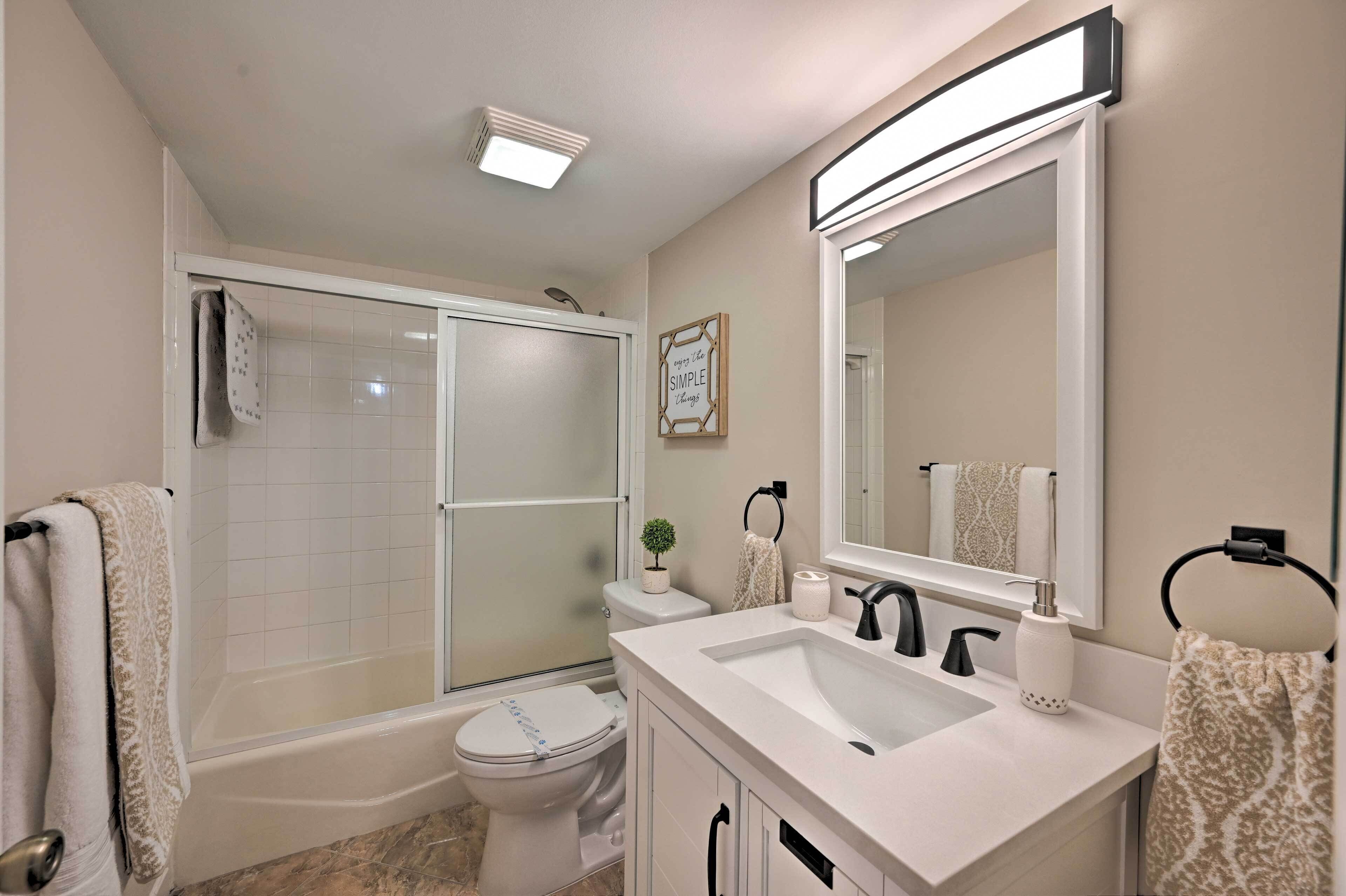 Een moderne badkamer met douche, toilet en wastafel.