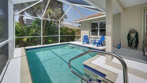 A swimming pool with a clear blue water, surrounded by a white canopy, and blue chairs on the patio. - Sunny Marco Island House < 3 Blocks to Beach! (Marco Island)
