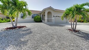 A residential house with a gravel driveway, palm trees, and a well-maintained garden. - Sunny Marco Island House < 3 Blocks to Beach! (Marco Island)