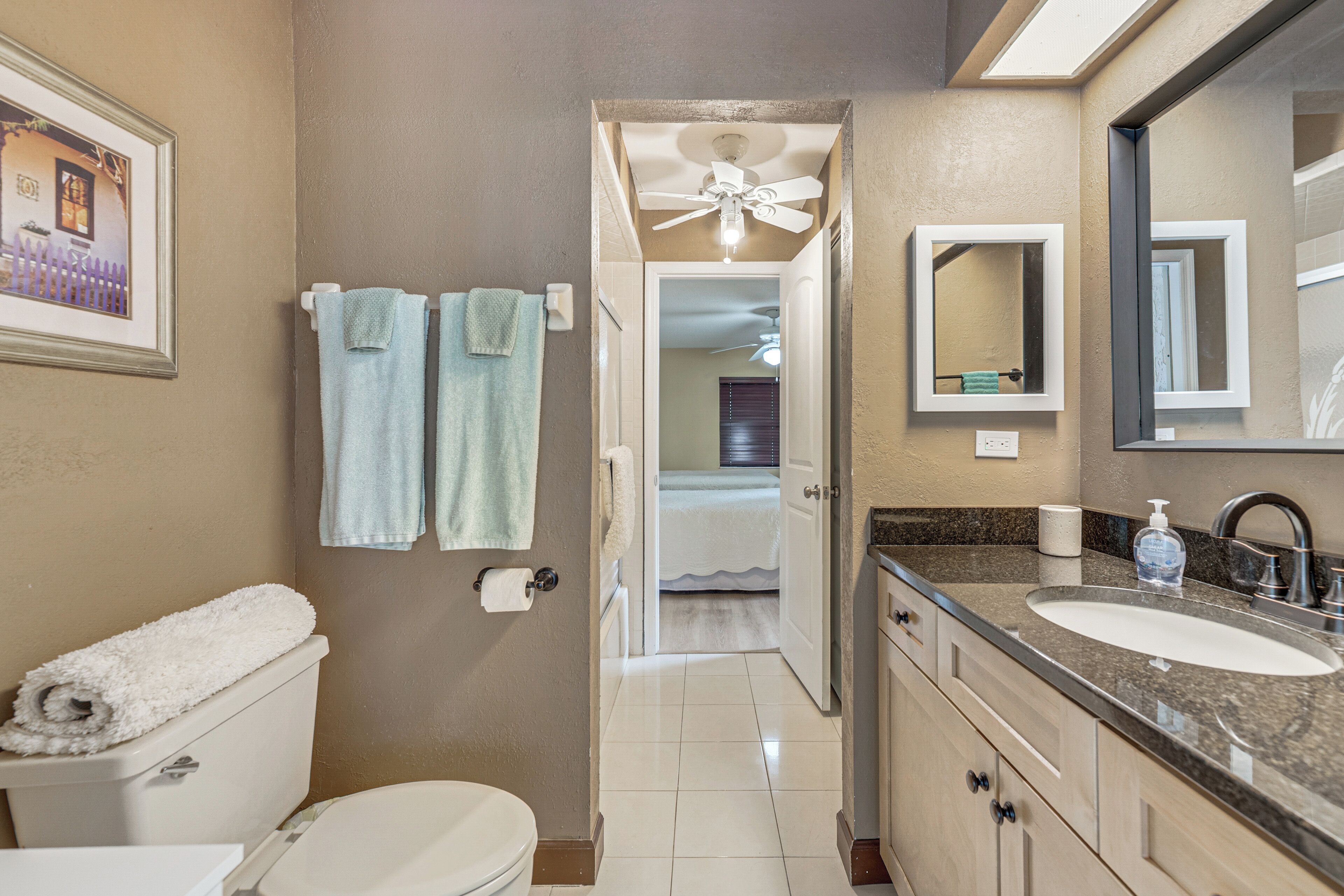 A bathroom with a toilet, sink, and towel rack.