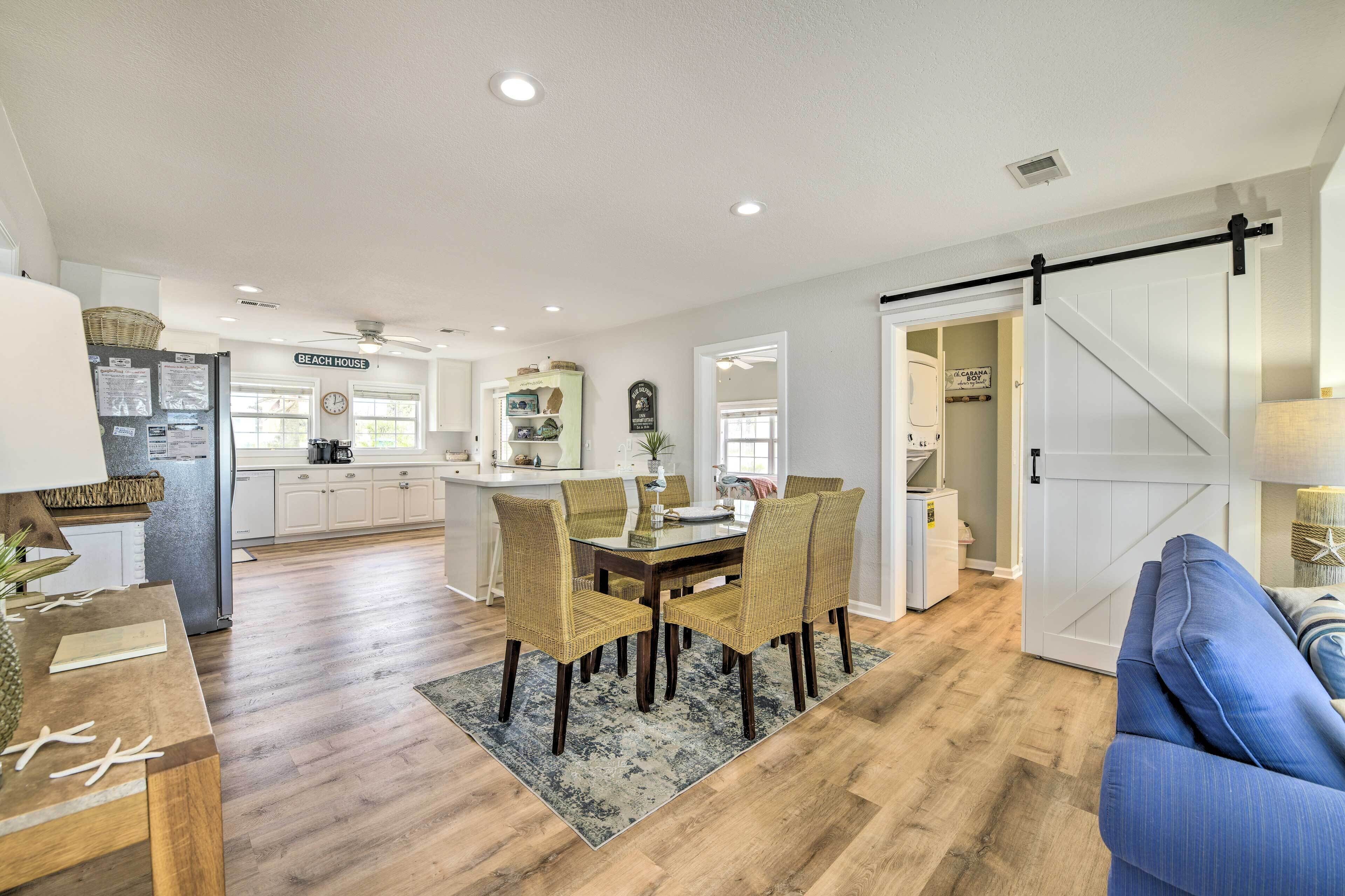 A spacious kitchen with a dining area, wooden flooring, and a sliding barn-style door.