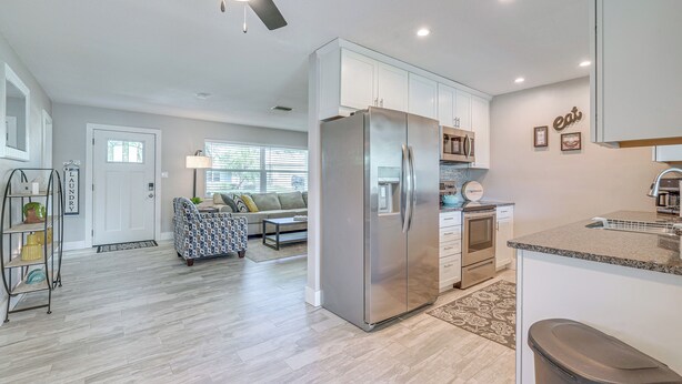 A modern kitchen with stainless steel appliances, a built-in oven, and a granite countertop. - Dock, Kayaks & Bicycles: Crystal River Getaway! (Crystal River)