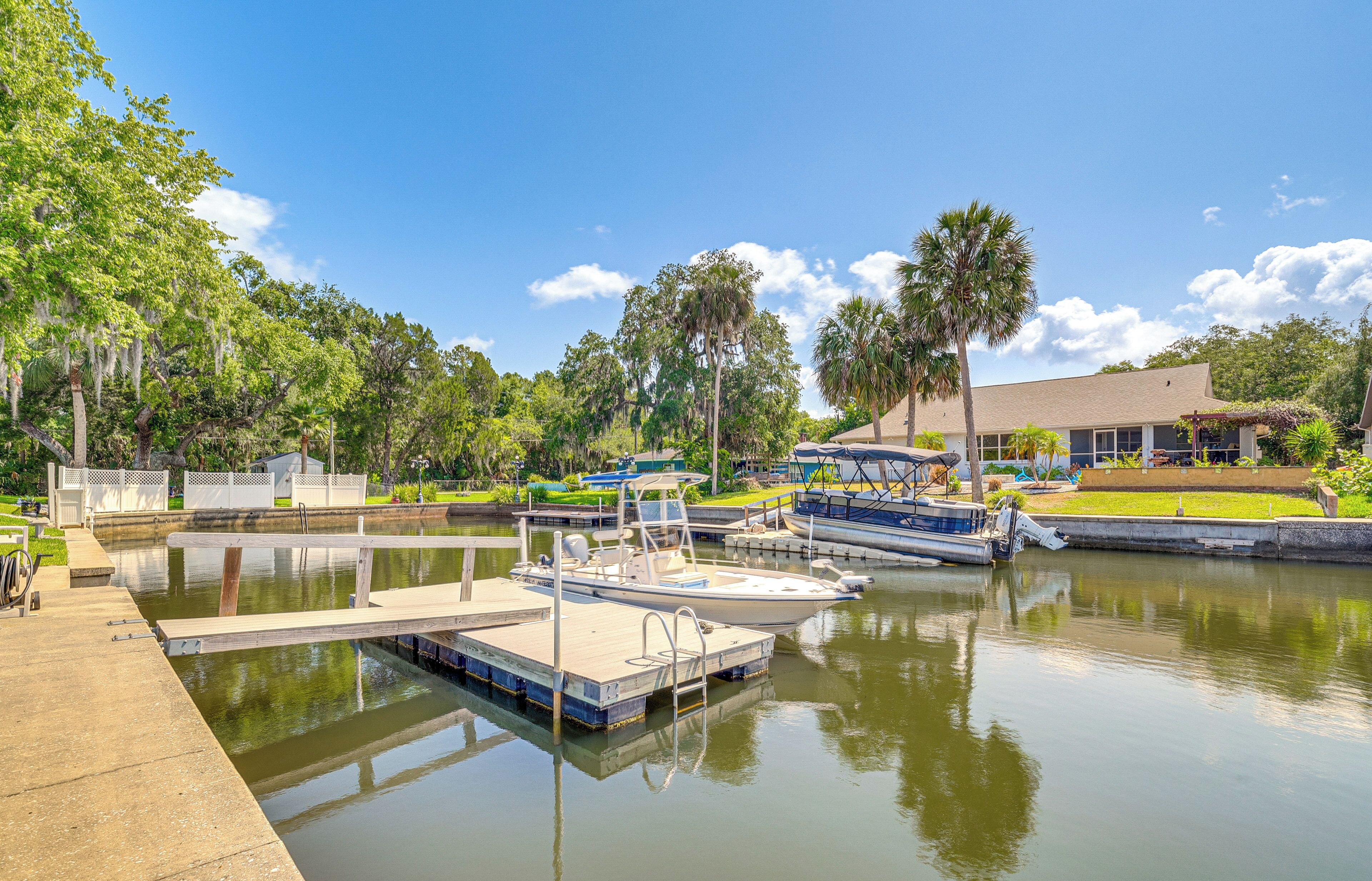 A marina with docked boats, a wooden pier, and a building with a covered area.