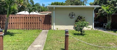 A fenced outdoor area with a pathway leading to a building with a sign that reads 'Hone of the BRAVO'.