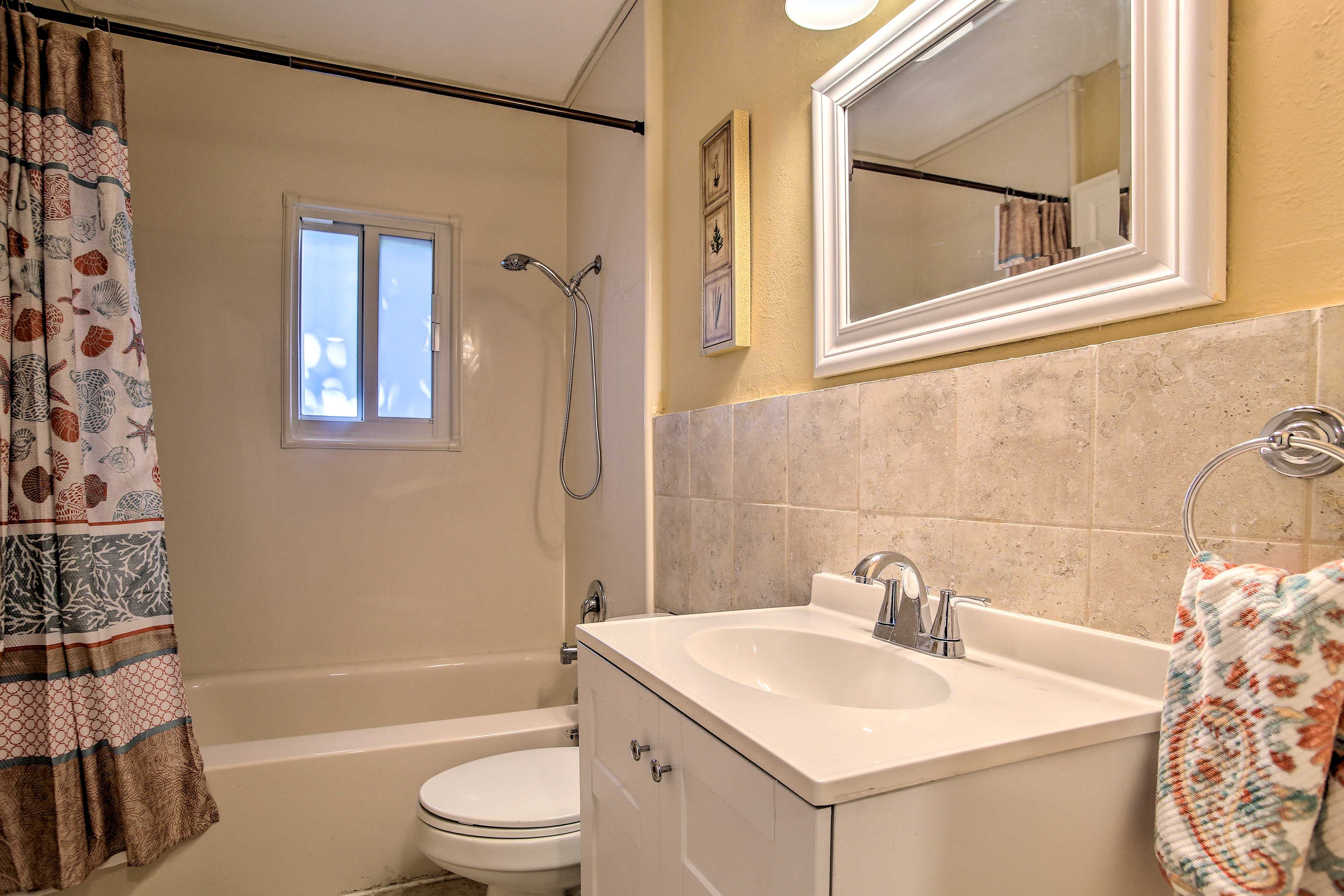 Un baño con bañera, inodoro y lavamanos.