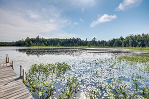 A wooden dock extending into a lake surrounded by dense forest. - Dog-friendly Park Falls Cottage w/ 5 Acres & Lake (Park Falls)