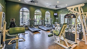 Ein Fitnessstudio mit Laufbändern, Crosstrainern und Kraftgeräten.
