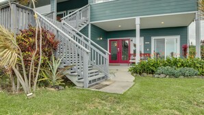 A two-story house with a grey staircase leading to a red door. - Ocean Views Peaceful Retreat Volcano & Beaches (Naalehu)