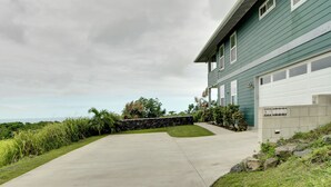 A residential house with a driveway leading to a garage. - Ocean Views Peaceful Retreat Volcano & Beaches (Naalehu)
