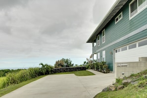 A residential house with a driveway leading to a garage. - Ocean View Peaceful Sanctuary Spastyle Shower (Naalehu)