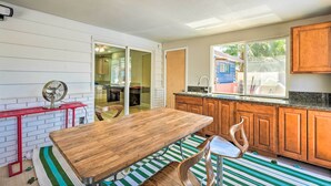 A kitchen with a wooden table, a red metal stand, and a striped rug. - Las Vegas Getaway w/ Patio & Grill: ~3mi to Strip! (Las Vegas)