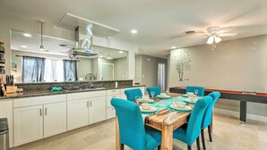A modern kitchen with white cabinets, a wooden dining table with teal chairs, and a pool table. - Las Vegas Getaway w/ Patio & Grill: ~3mi to Strip! (Las Vegas)