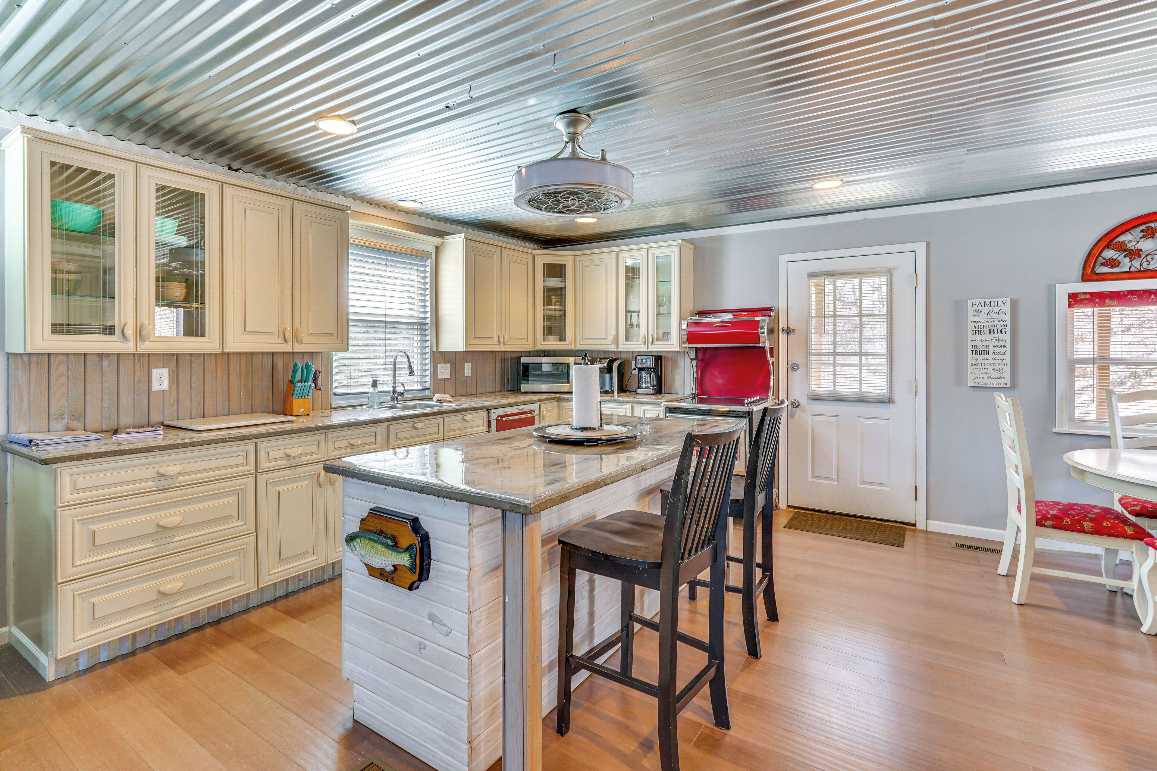 A kitchen with wooden cabinets, a central island, and a red appliance.