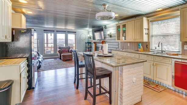 A spacious kitchen with a large island, wooden cabinets, and a view to the living area.