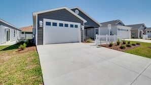 Ein modernes Einfamilienhaus mit Garage, kleinem Vorgarten und weißem Zaun.