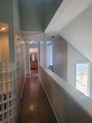 Stylish hallway leads to a room with a large window and a door to another area.