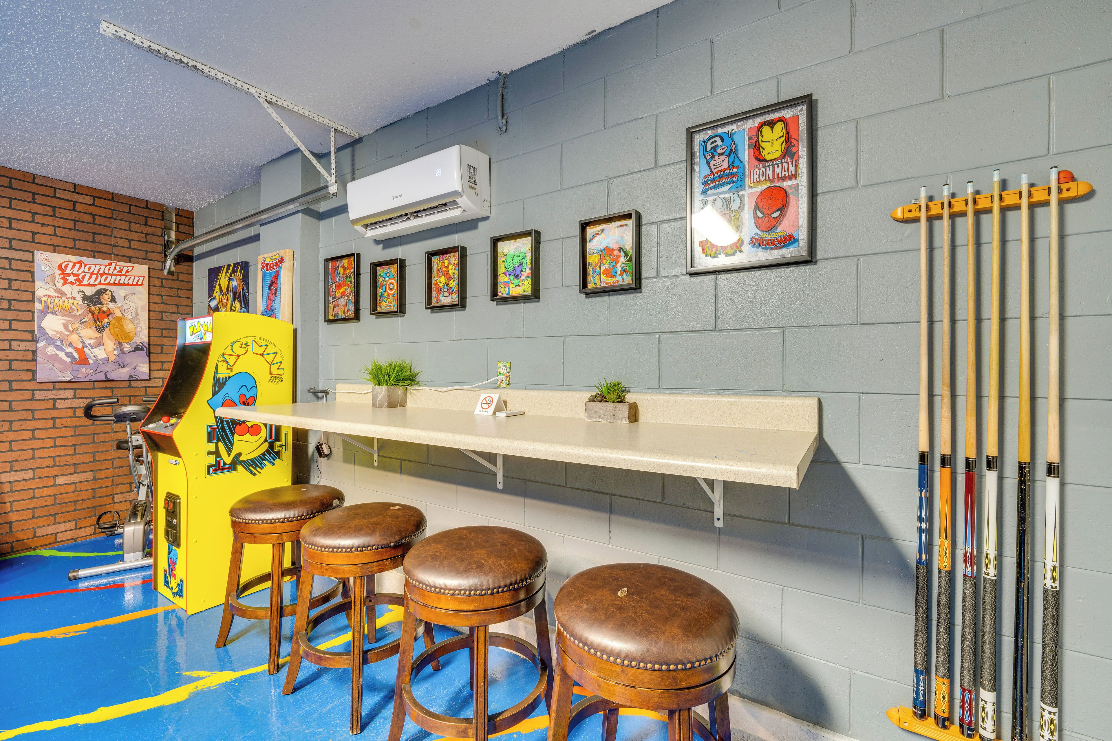 Eine Bar mit Hockern, einer Theke und gerahmten Postern an der Wand.