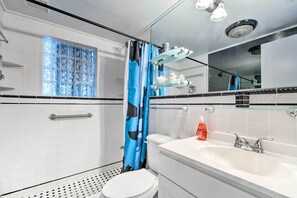 A modern bathroom with a white toilet, a glass shower enclosure, a white sink with a chrome faucet, and a mirror above the sink. - Canalfront Hudson Home W/private Dock & Yard! (Hudson)