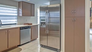 A modern kitchen with stainless steel appliances, beige cabinetry, and a dishwasher. - 'sand Dollar' Jenson Beach Home w/ Pool Access! (Jensen Beach)