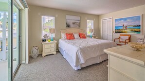 A bedroom with a large bed, a nightstand, a dresser, and a window with blinds. - Waterfront Home w/ Dock, Kayaks, Pool + More! (Crystal River)