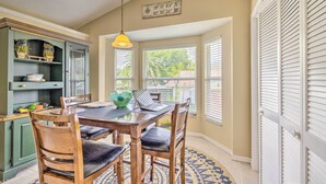 A dining area with a wooden table, chairs, and a yellow pendant light. - Waterfront Home w/ Dock, Kayaks, Pool + More! (Crystal River)