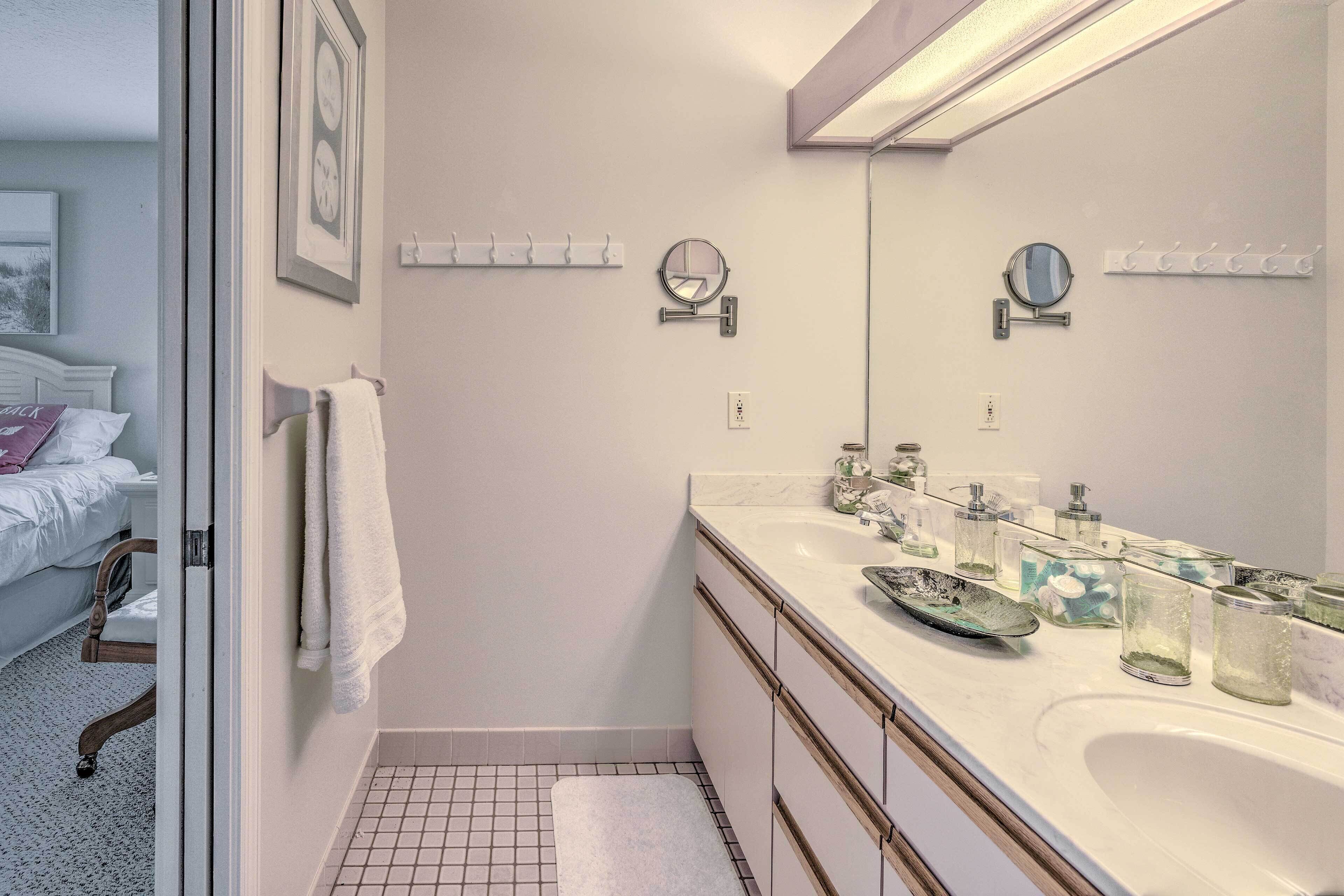 Een moderne badkamer met een grote spiegel, twee wastafels en een douche.