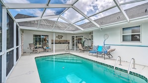 A covered swimming pool with lounge chairs and a kitchen area. - Waterfront Home w/ Dock, Kayaks, Pool + More! (Crystal River)