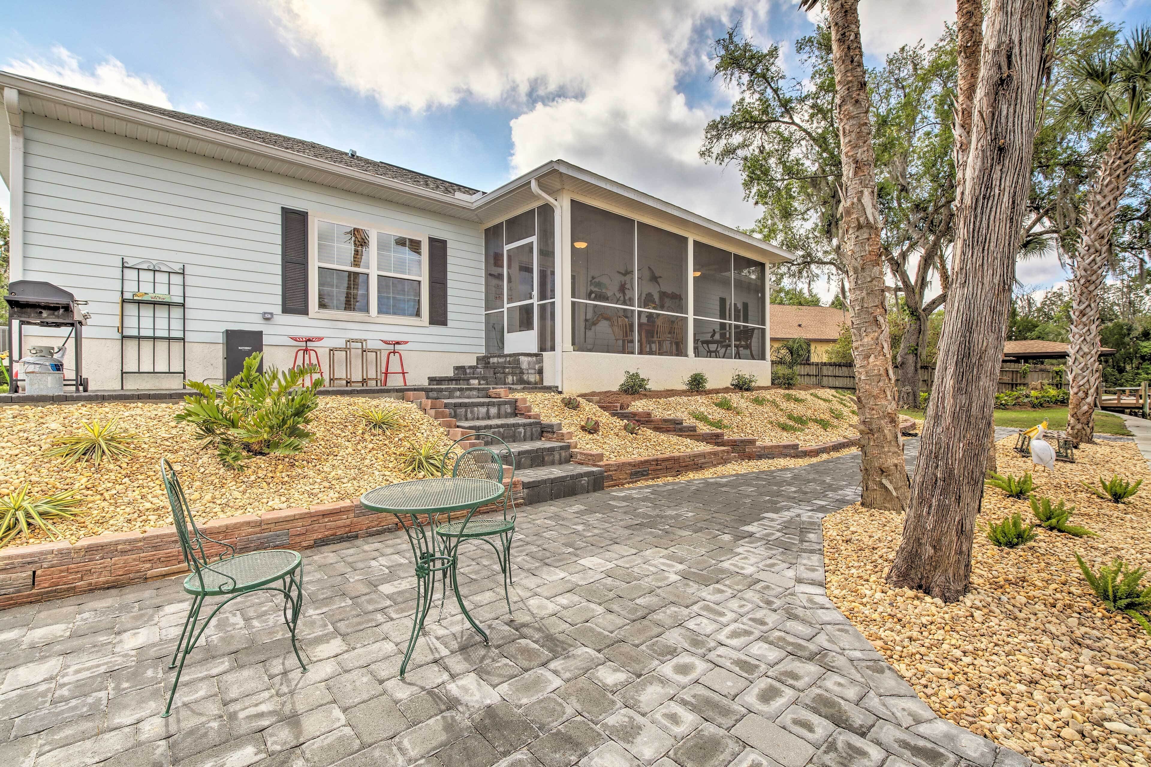 A house with a covered patio, outdoor seating, and a landscaped garden.