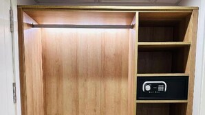Un armario de madera con varias estantes y cajones, una radio sobre uno de los estantes, y una puerta en el lado izquierdo.
