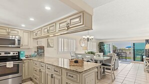 A kitchen with granite countertops, stainless steel appliances, and a large island. - Miramar Beach Retreat - Beachfront & Poolside (Miramar Beach)