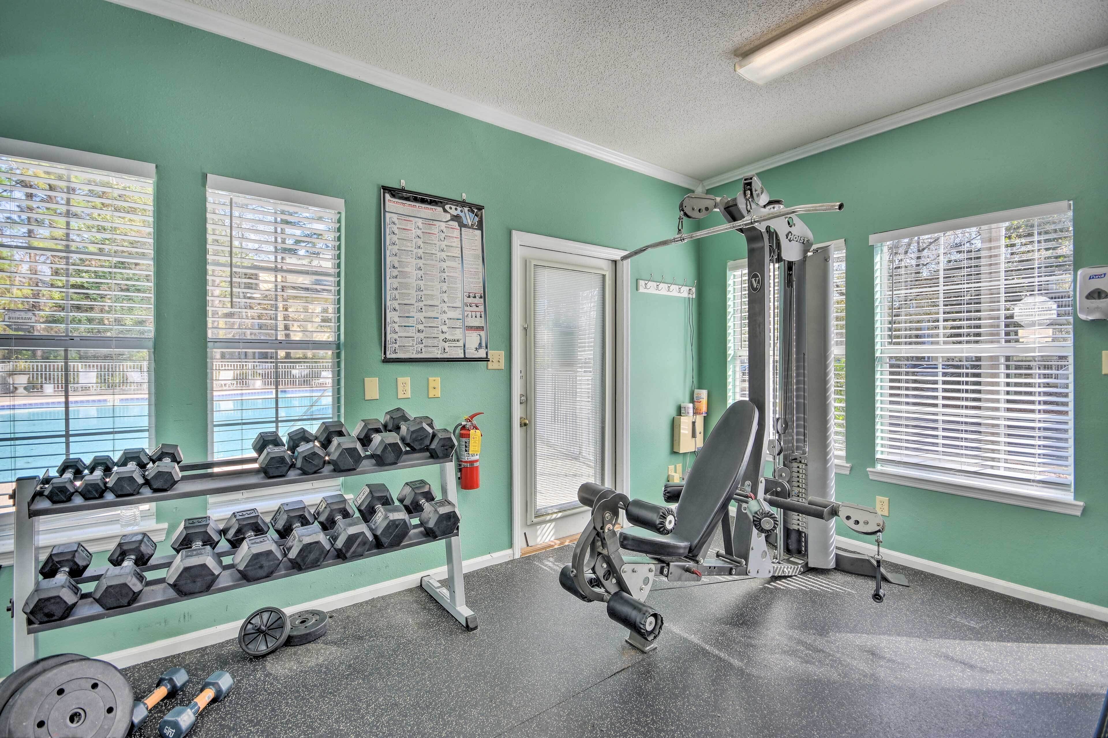 A gym with dumbbells, weight plates, and exercise machines.