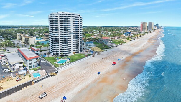 A beachfront hotel with a large building, a sandy beach, and the ocean. - Oceanfront Daytona Beach Condo w/ Beach Views! (Daytona Beach)