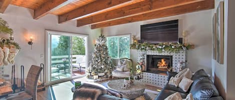Una sala acogedora con chimenea, sofá de cuero y un árbol de Navidad.