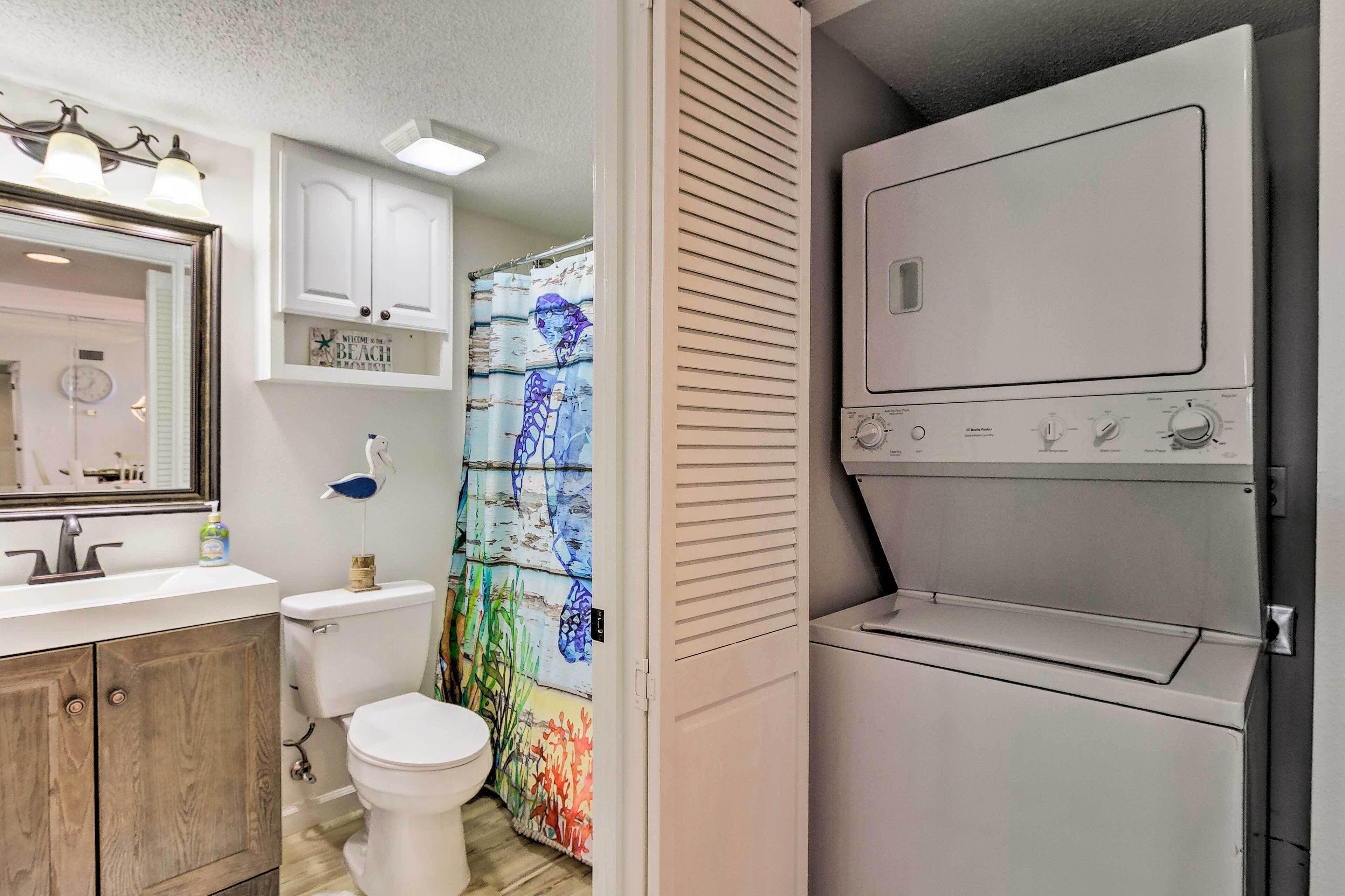 A bathroom with a toilet, sink, mirror, and a wall-mounted heater.