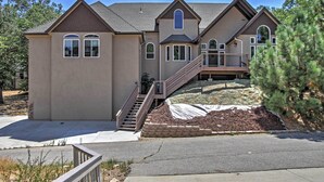 A two-story house with a front porch, a staircase leading to the second floor, and a landscaped front yard.