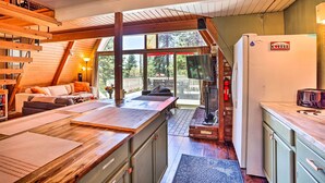 A cozy kitchen with a wooden countertop, a refrigerator, and a dining area with a table and chairs.