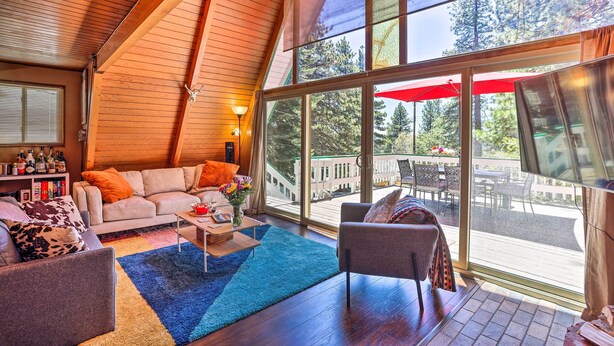 A cozy living room with a large window, a fireplace, and a television.