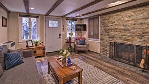 A cozy living room with a stone fireplace, wooden beams, and a comfortable seating area. - Cozy, Pet-friendly Mtn Cabin: 1 Mi to Lake Gregory (Crestline)